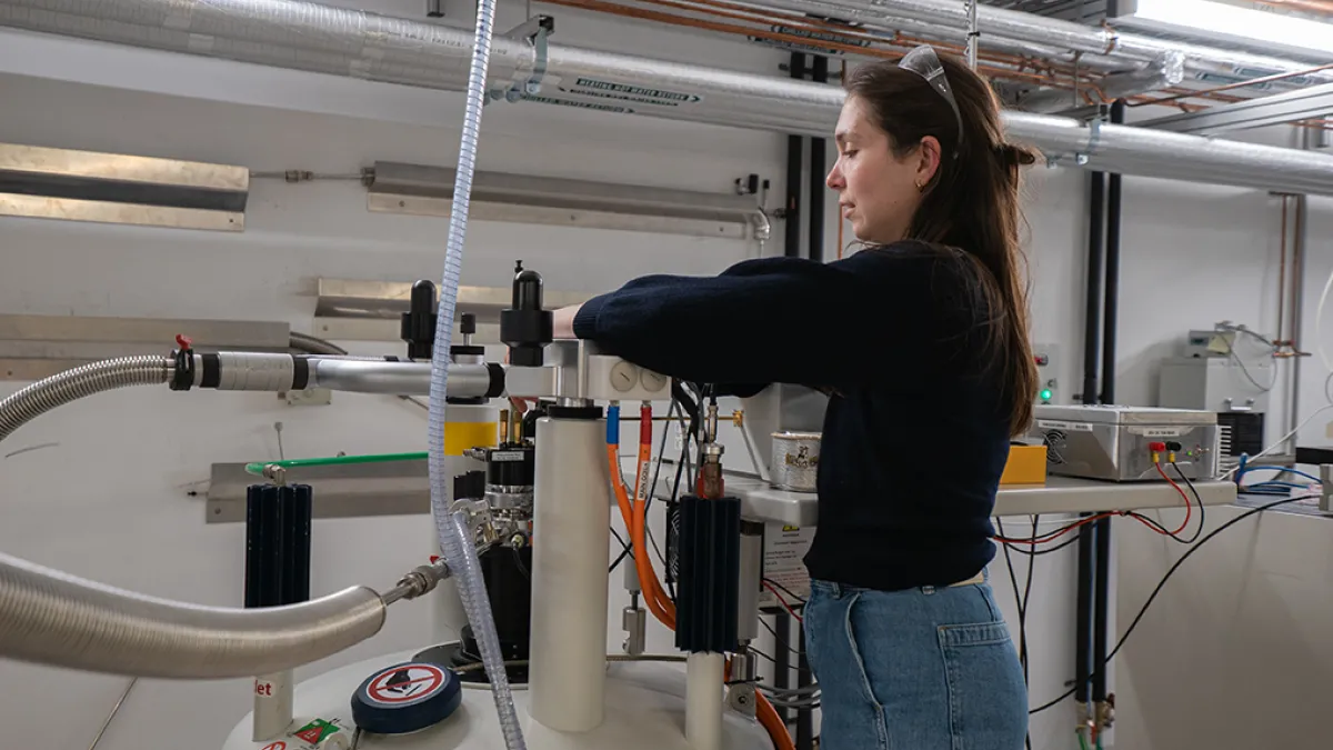 Dr Martyna Judd in a technical laboratory working on equipment.