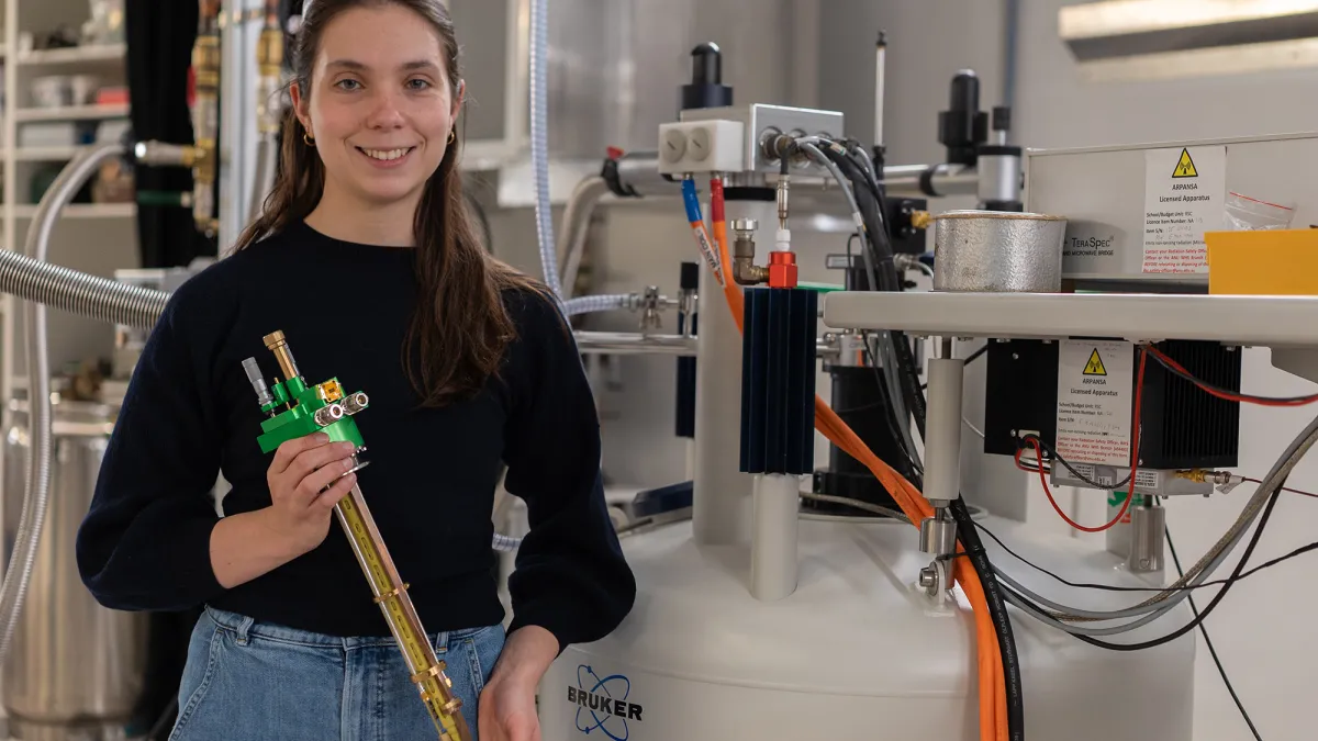 Dr Martyna Judd in a technical laboratory holding instrumentation