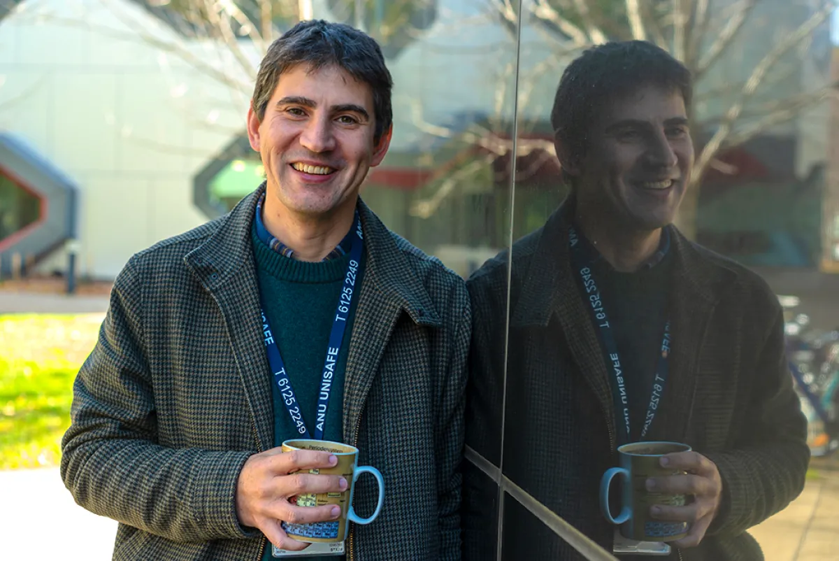 Professor Nick Cox leaning on the side of a building with his reflection /