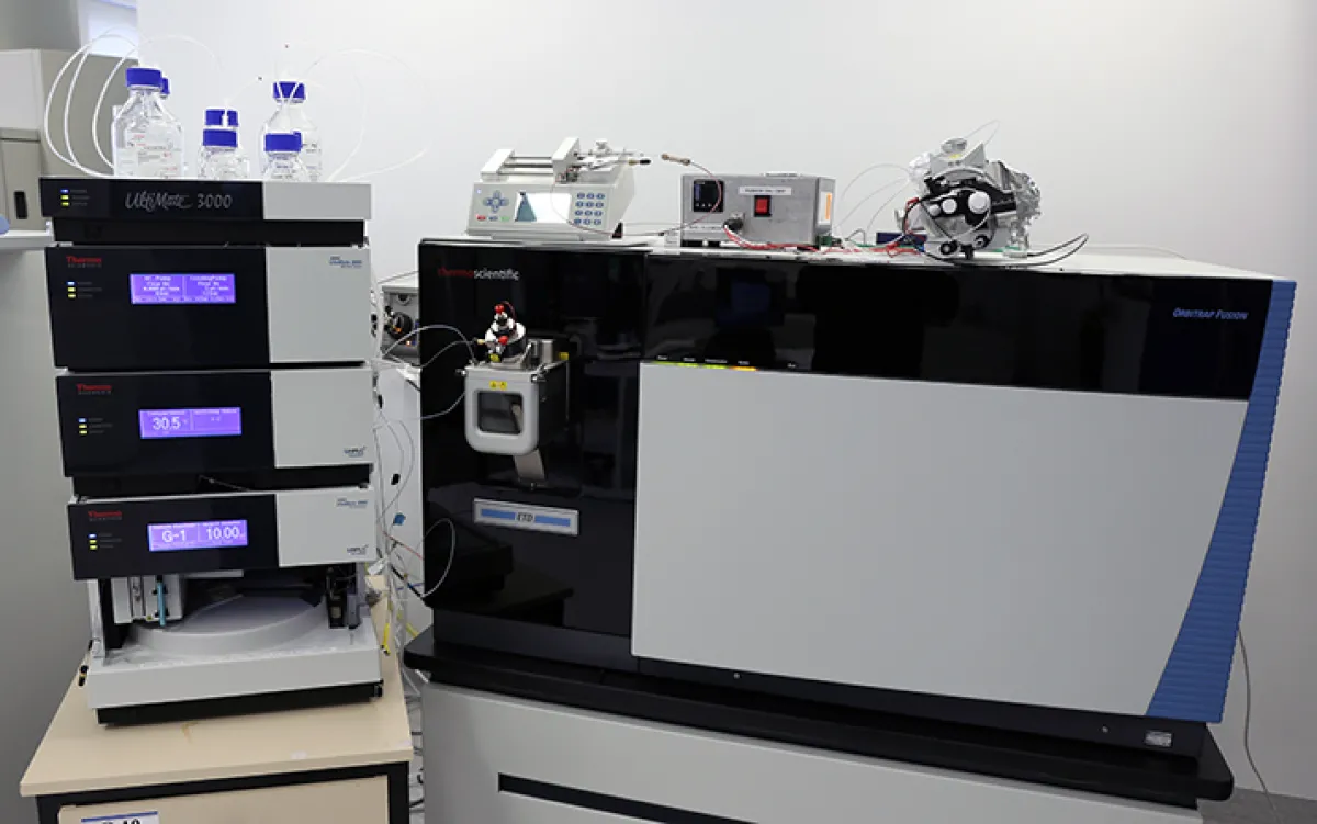 Complex laboratory equipment including a chromatography system and various scientific instruments, displayed in a clean, organized lab setting.
